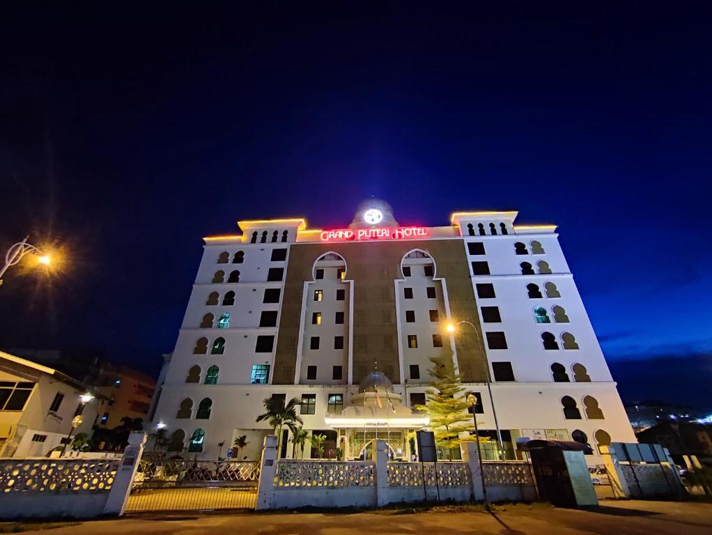 瓜拉丁加奴The Grand Puteri Hotel的夜间标有标志的酒店大楼