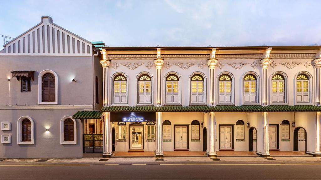 马六甲The NINES HOTEL Malacca的街道角落上一座白色的大建筑