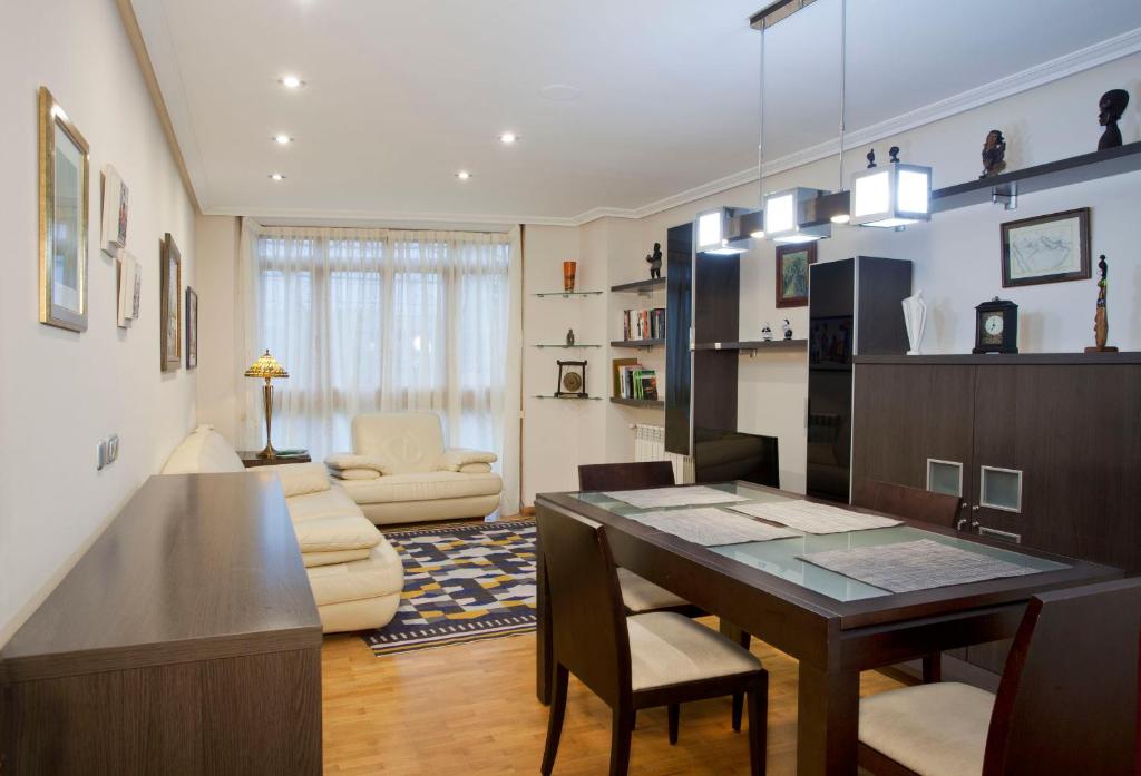 奥维多Apartamento de La Casona de Riomera的一间带餐桌的客厅和一间带沙发的客厅