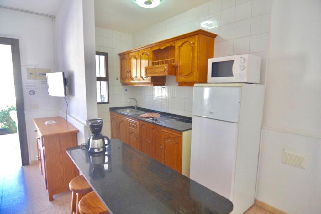 莫甘Comfortable Apartment in Puerto Rico的厨房配有白色冰箱和木制橱柜。