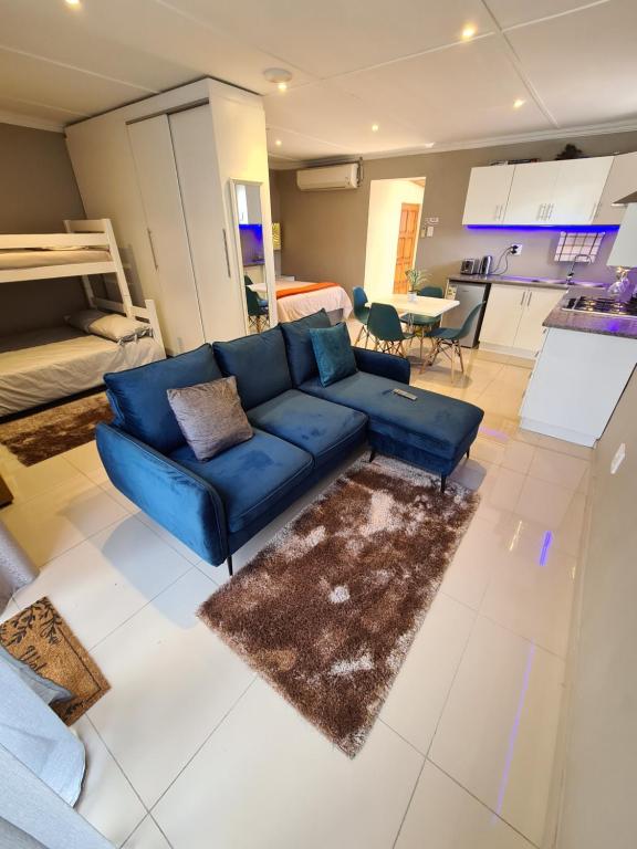 德班ARCHITECTS VIEW - VIP FAMILY SUITE的一间带蓝色沙发的客厅和一间厨房