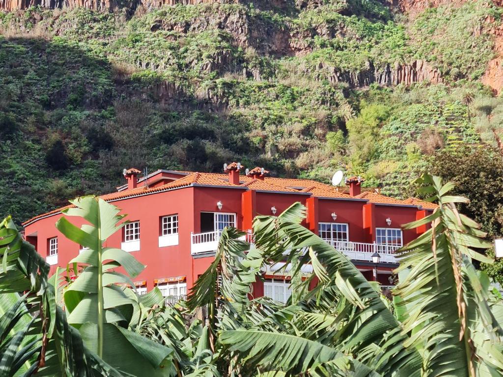 阿古洛Viviendas Vacacionales Escuela的一座橙色的建筑,在山前