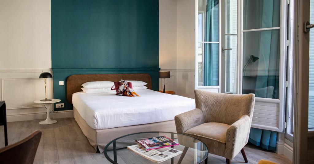 蒙彼利埃罗亚酒店的一间卧室配有一张床、一把椅子和一张桌子