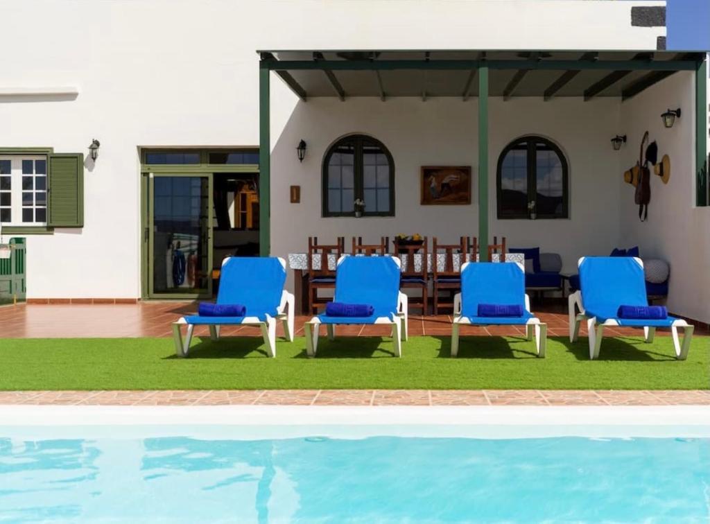 TinguatónPico Partido villa的一组蓝色椅子坐在游泳池旁