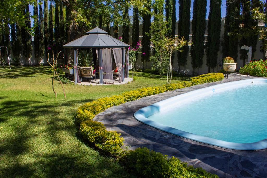 帕拉斯德拉富恩特Finca del Rocio的一个带凉亭的庭院内的游泳池