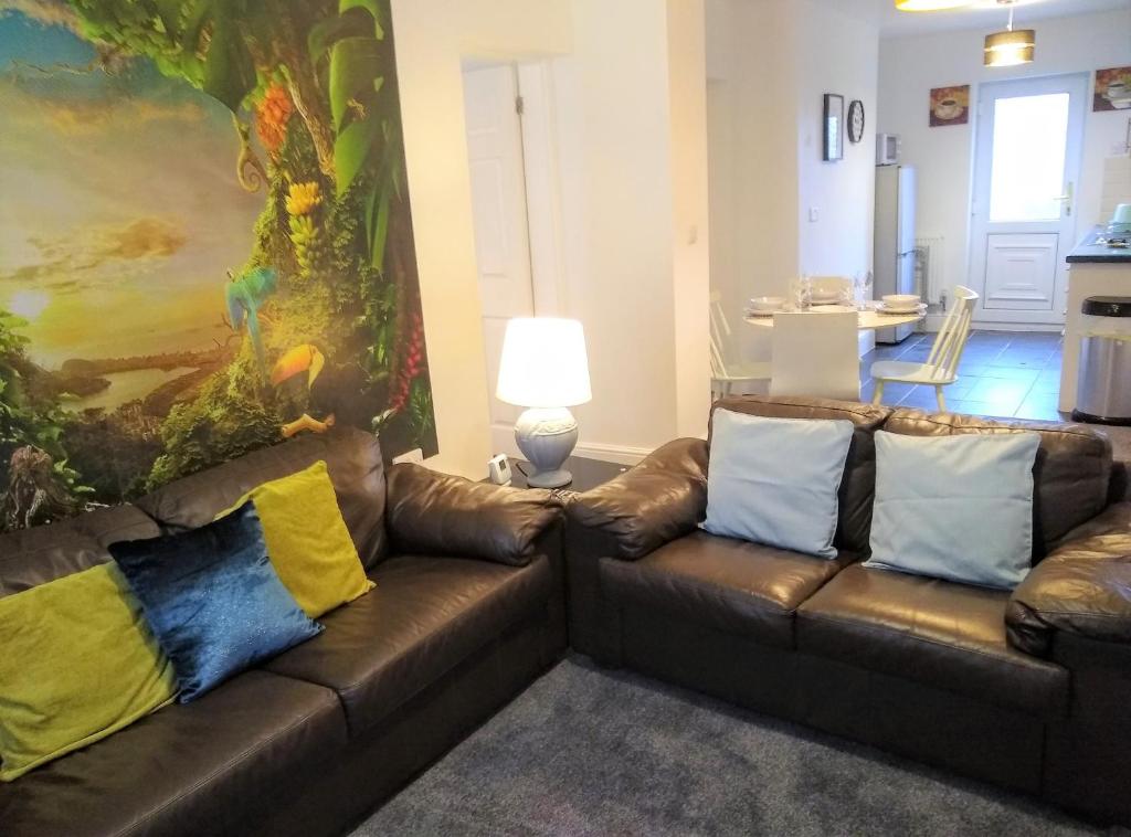圣海伦斯Modern comfy 2-Bedroom flat in St Helens的客厅配有2张带彩色枕头的棕色皮沙发