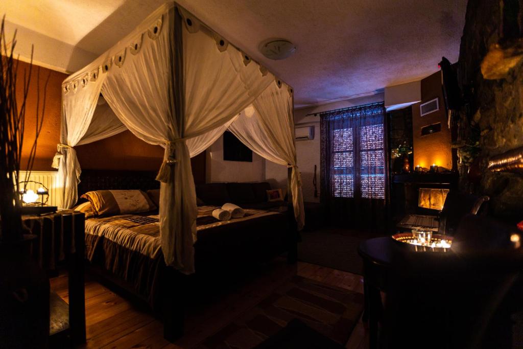 KraniáLa Moara Boutique Hotel的一间卧室配有一张带天蓬的床