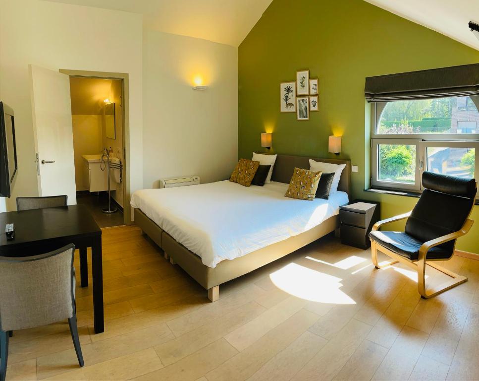 奥德海文利Hotel Bibois的一间卧室配有一张床、一张桌子和一把椅子