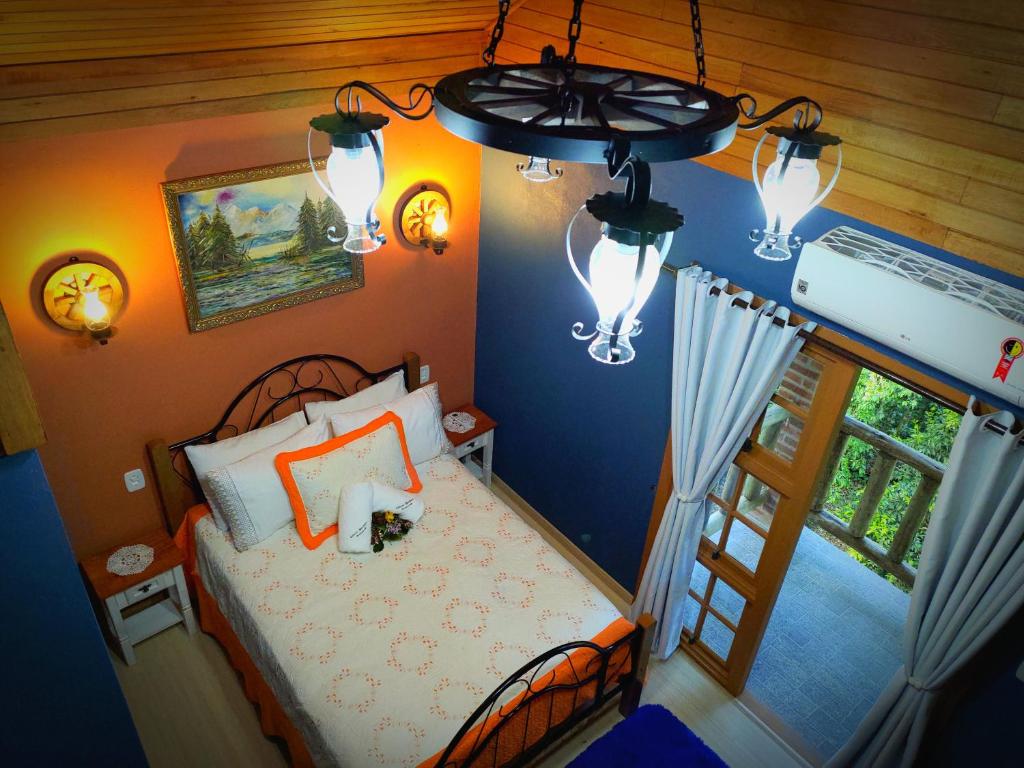 格拉玛多Cabana Drechsler Gramado的一间卧室配有床、窗户和灯