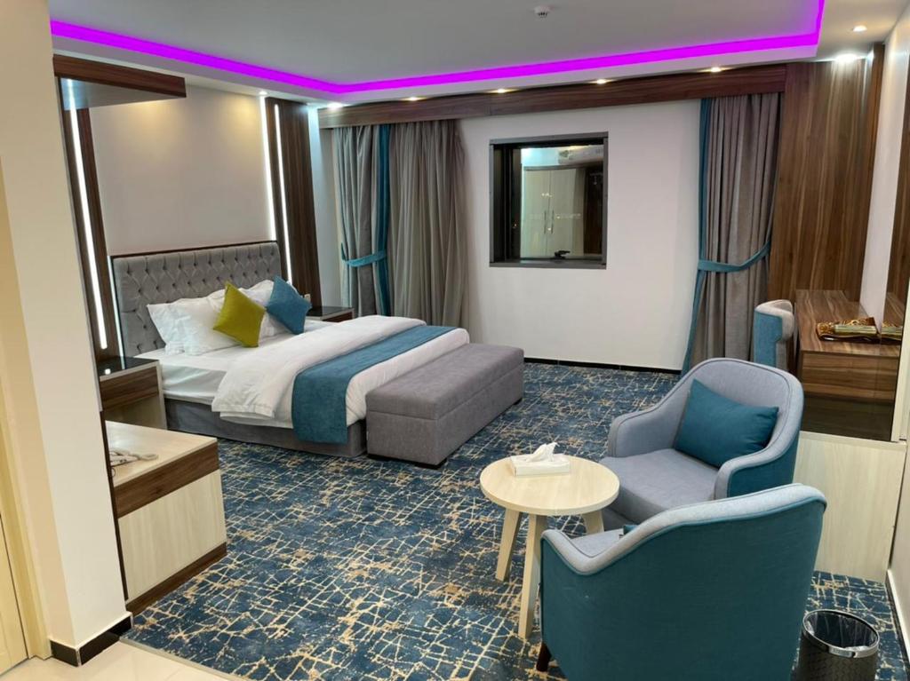 艾卜哈Mabeet Residances的酒店客房带一张床、一张桌子和椅子