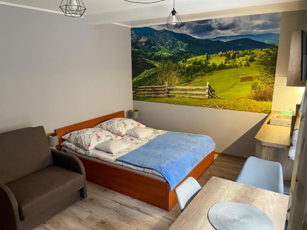 维斯瓦Pokoje Beata的一间卧室配有一张床和一把椅子,墙上挂着一幅画