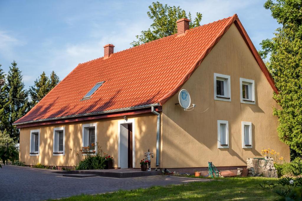瓦尔米亚地区利兹巴克Domek na wzgórzu Blanki的一座带橙色屋顶的大房子