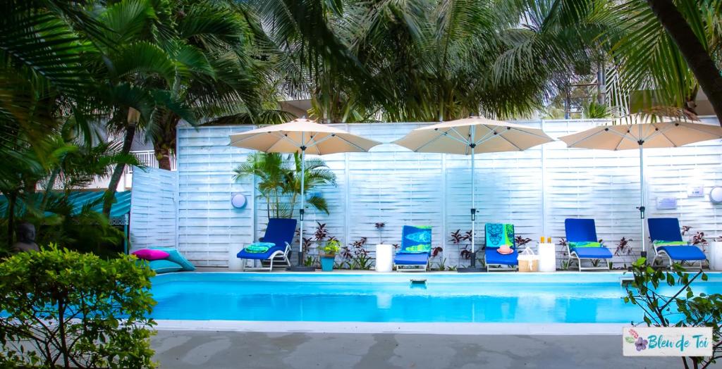 佩雷贝勒布鲁德托伊精品旅馆的一个带蓝色椅子和遮阳伞的游泳池