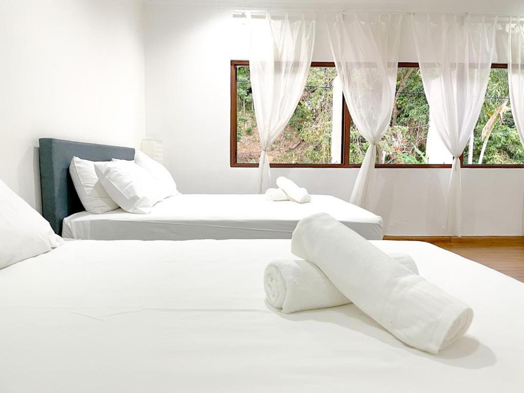 吉隆坡Mas Homestay的带2扇窗户的客房内的2张白色床