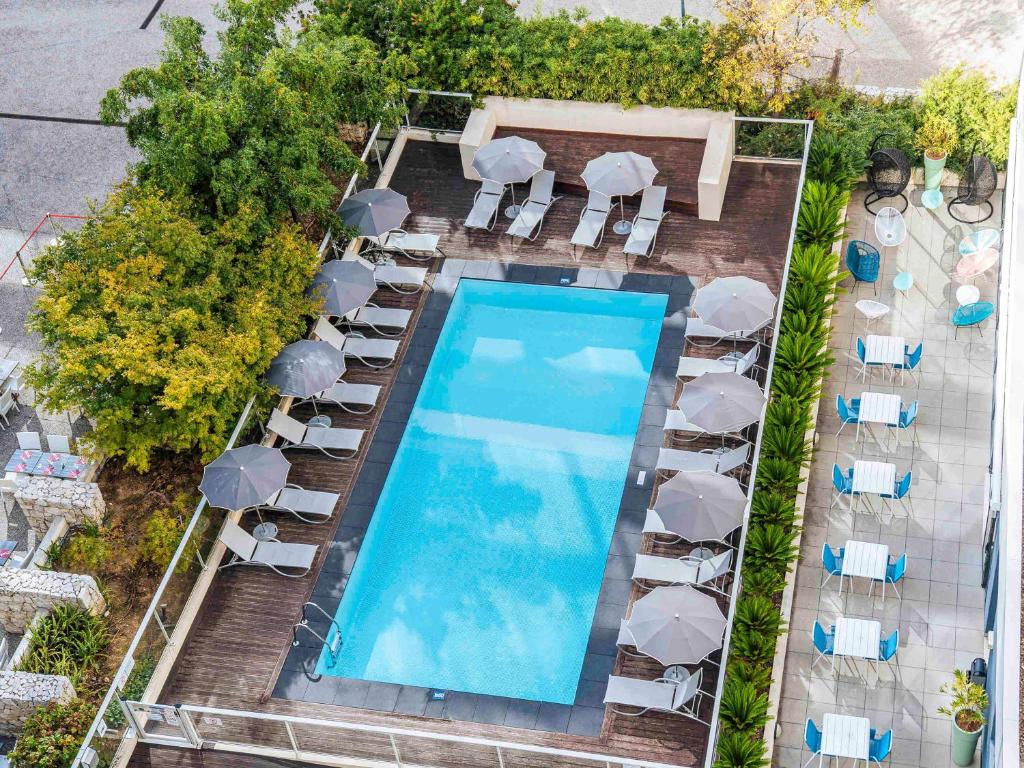 尼斯尼斯机场宜必思尚品酒店的享有带椅子和遮阳伞的游泳池的上方景色