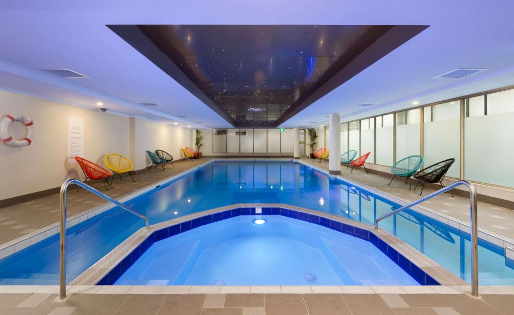 悉尼悉尼雷吉斯中央酒店的一座带椅子的建筑中的游泳池