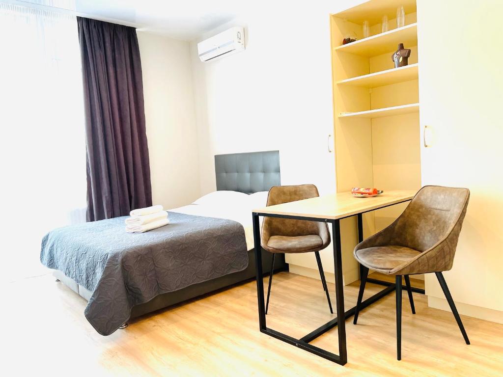 基辅Mira Apart-Hotel的卧室配有一张床、一张桌子和椅子