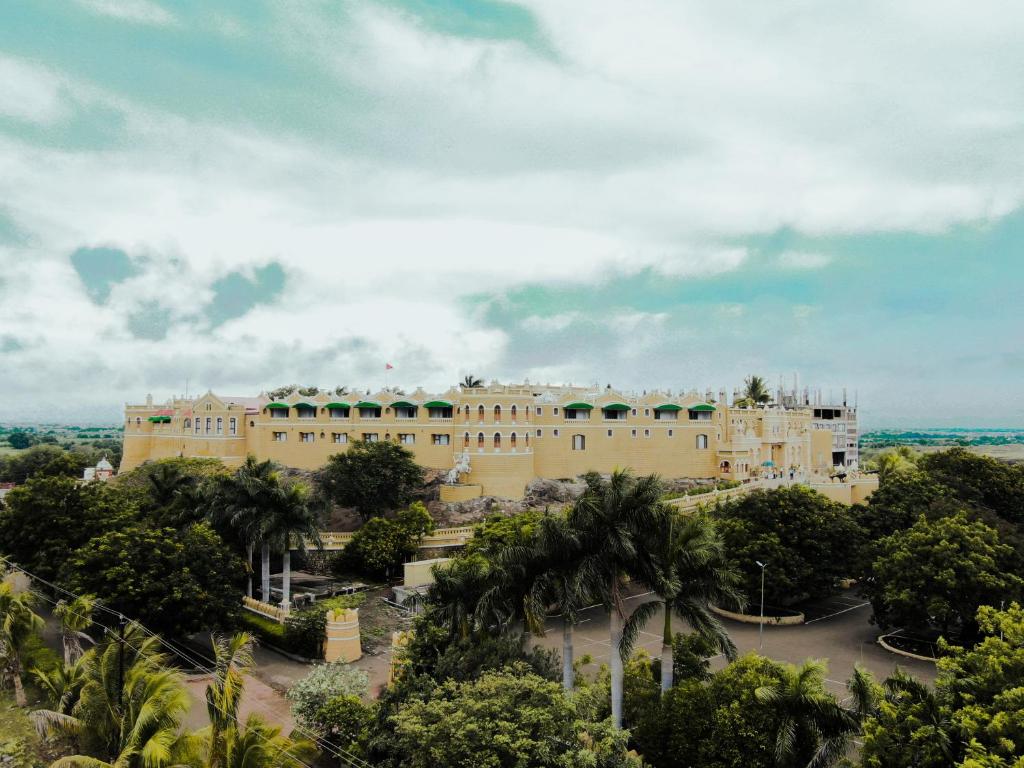 拉杰果德Heritage Khirasara Palace的一座棕榈树环绕的大建筑