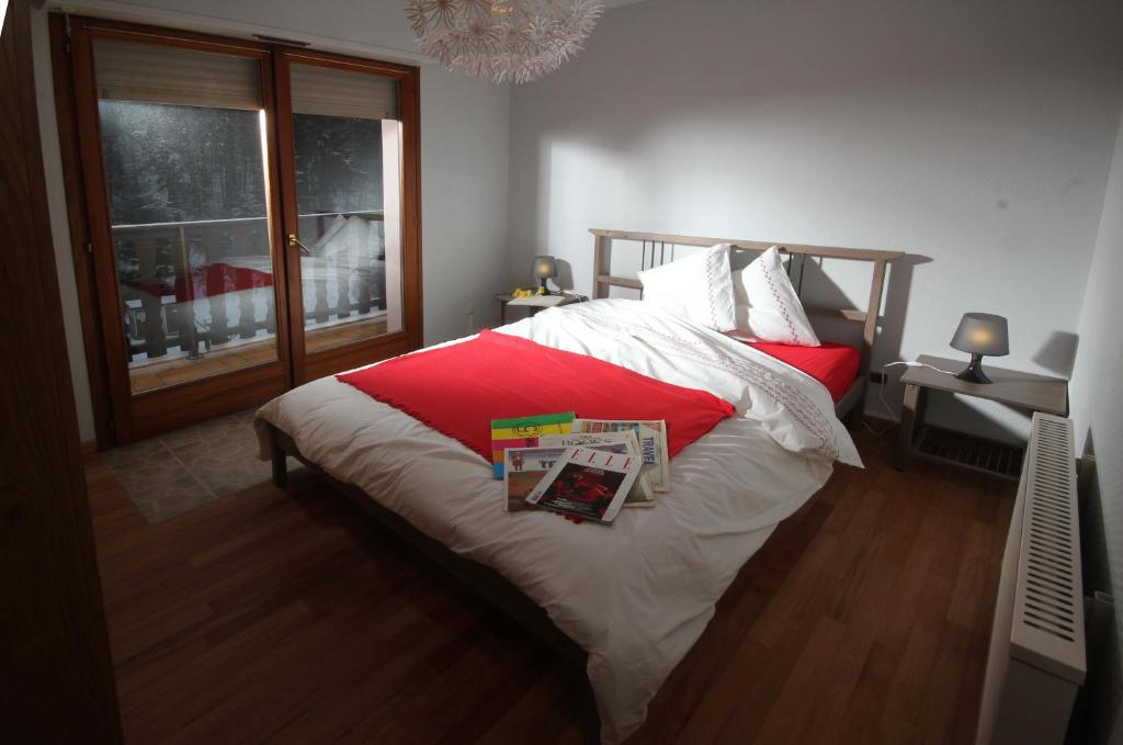 勒奥瓦尔德阿德莱德公寓的一间卧室配有一张铺有红白色床单的床和一扇窗户。