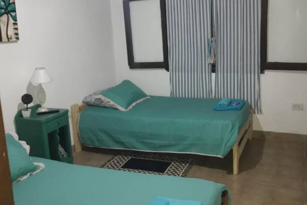 戈亚Depto La Cuni的一间卧室配有两张床和一张带台灯的桌子