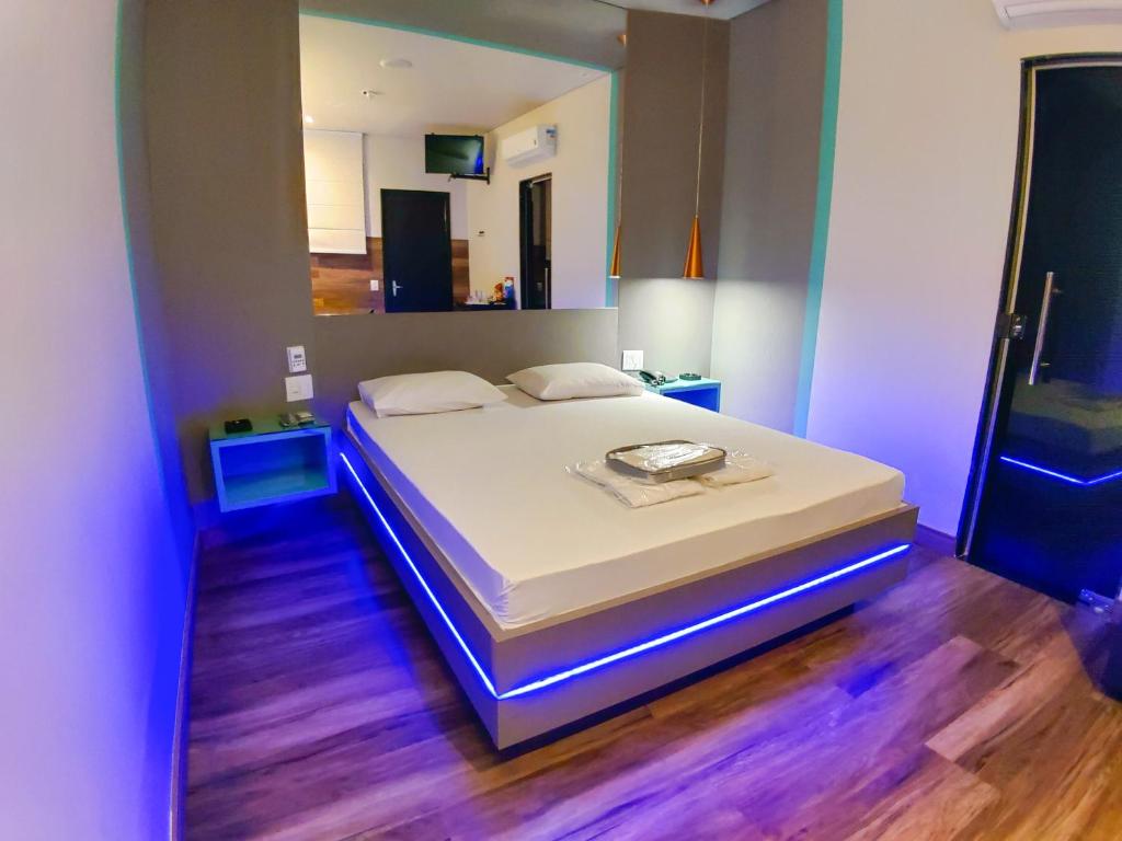 贝洛奥里藏特Motel Caribe的一间卧室配有一张白色的蓝色调床