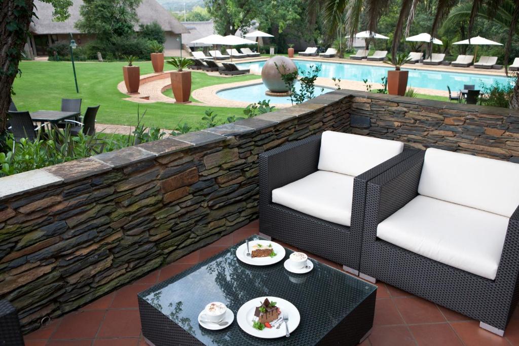 马加利斯堡Valley Lodge & Spa的庭院配有两把椅子和一张桌子,上面有食物