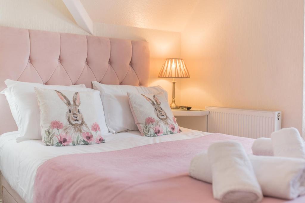 温德米尔Rayrigg Villa at Windermere的一间卧室配有一张带粉红色床头板的大床