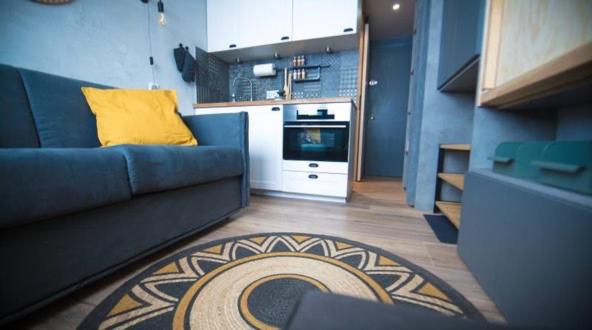 蒂涅Cosy - Appartement 2 personnes - Tignes le Lac - 415 - Le Palafour的客厅配有蓝色的沙发和黄色的枕头