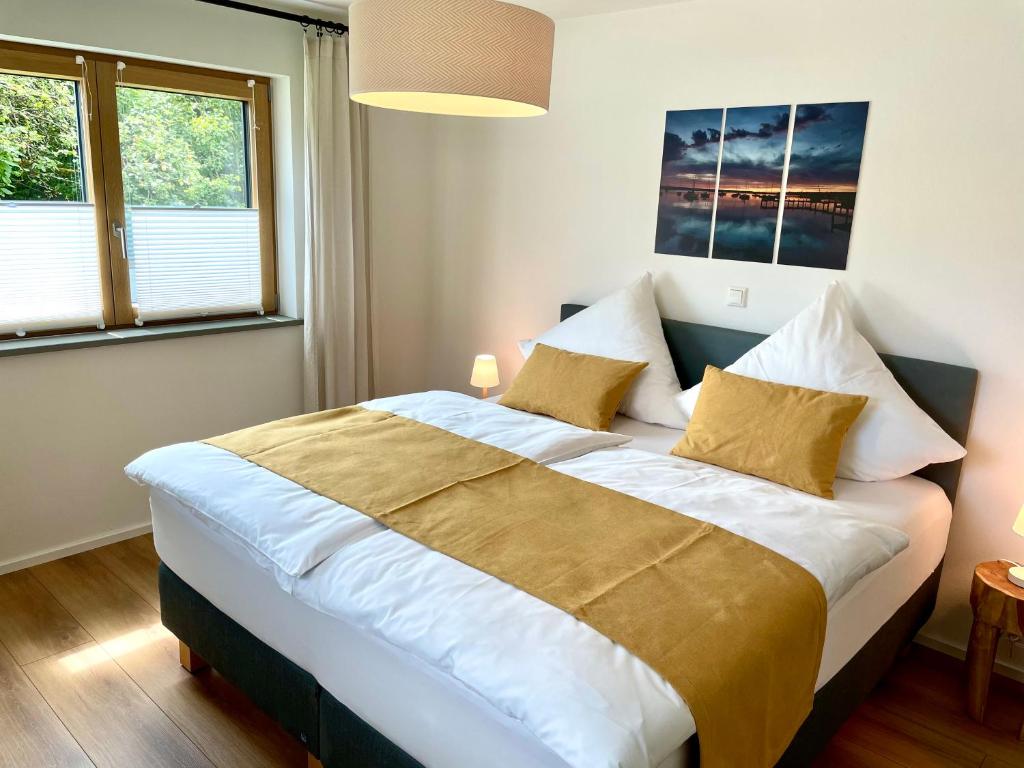 阿默湖畔因宁Sweet Home Apartment Ammersee - eco-friendly, Boxspring, Garden, WiFi的卧室配有一张带白色床单和枕头的大床。