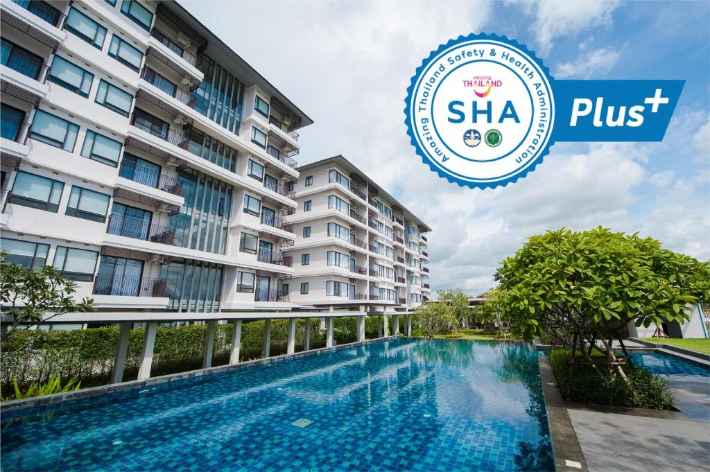 Si Maha PhotBurgundy Residence 304的大楼前设有游泳池的酒店