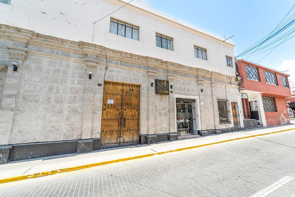 阿雷基帕Hotel La Posada Del Sol的街道上一座带木门的古老石头建筑
