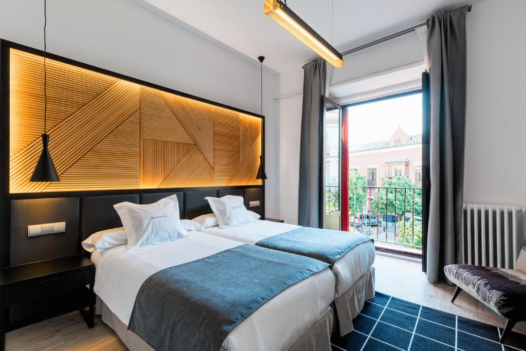 塞维利亚塞维利亚酒店的一间卧室设有一张大床和一个大窗户