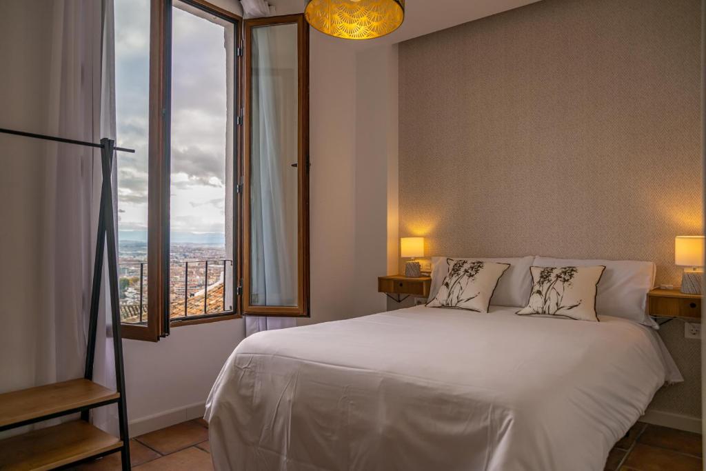 格拉纳达Florentia San Nicolás的卧室设有白色的床和大窗户