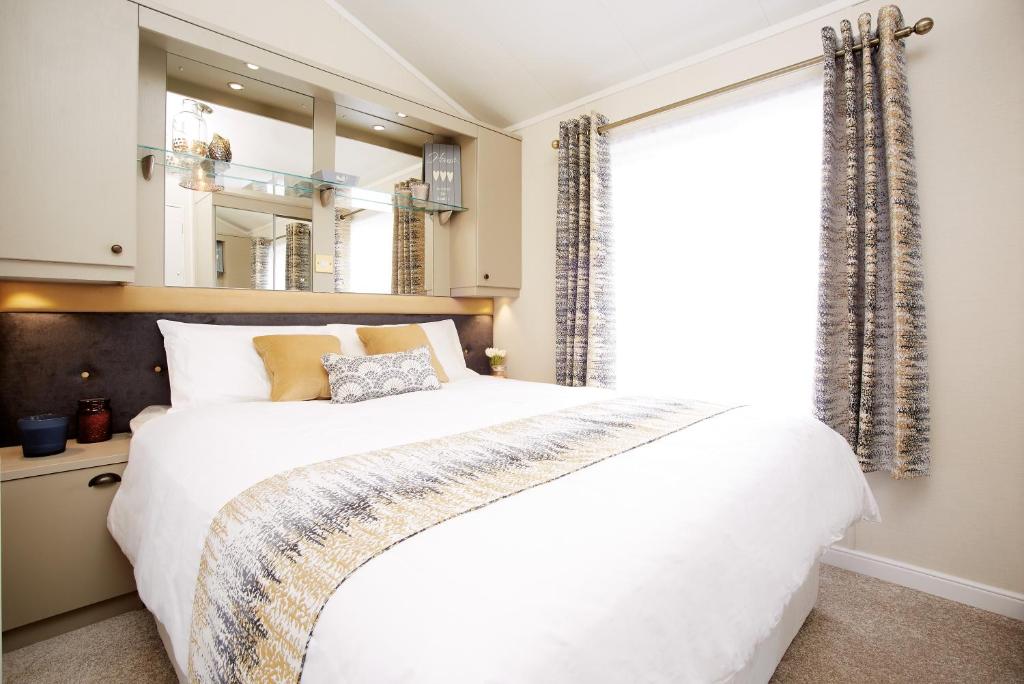 约克JJs Lodge Azalea的卧室设有一张白色大床和一扇窗户。