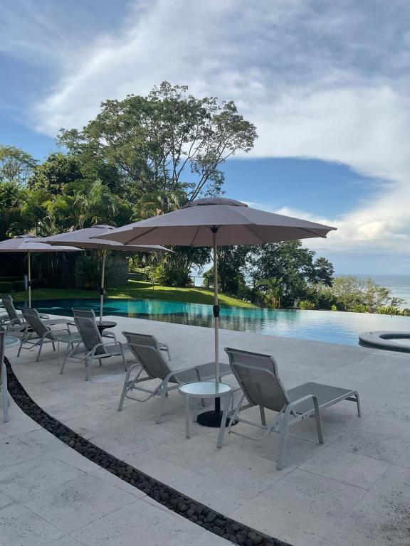 塔尔科莱斯Residence Nativa Las Vistas, appartement的游泳池旁配有遮阳伞的桌椅