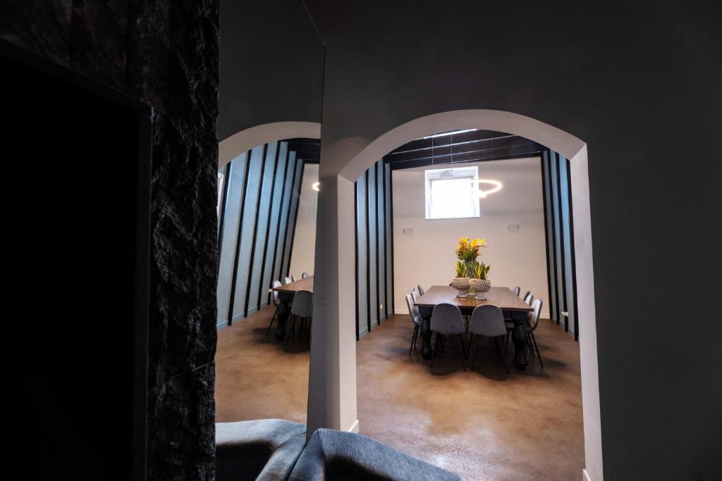 阿奇雷亚莱Riflessi Acireale Palace Suites的用餐室,配有一张桌子和花瓶