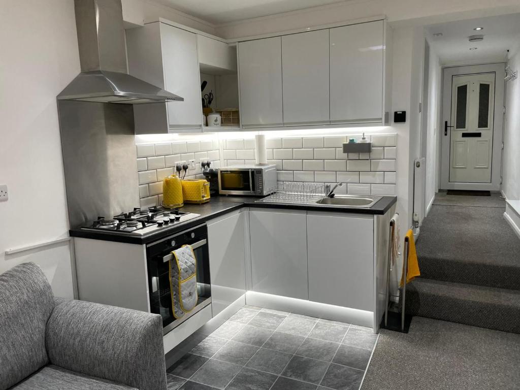 诺丁汉Balco Sherwood Studio的厨房配有白色橱柜和炉灶烤箱。
