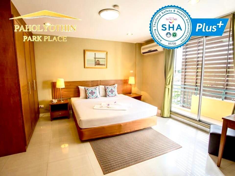 曼谷Paholyothin Park Place的酒店客房,配有床和标志