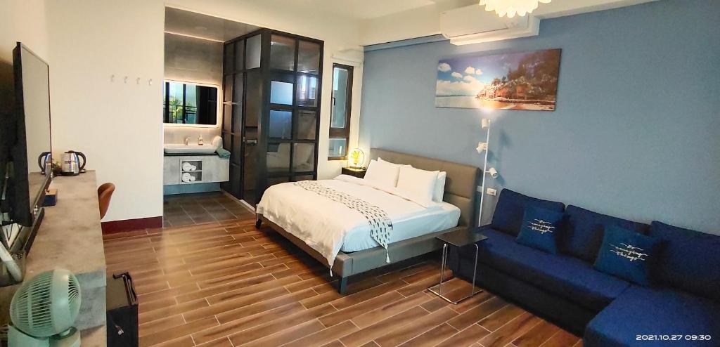 金宁乡嚨口十二之一民宿Longcall 12-1的一间卧室配有一张床和一张沙发