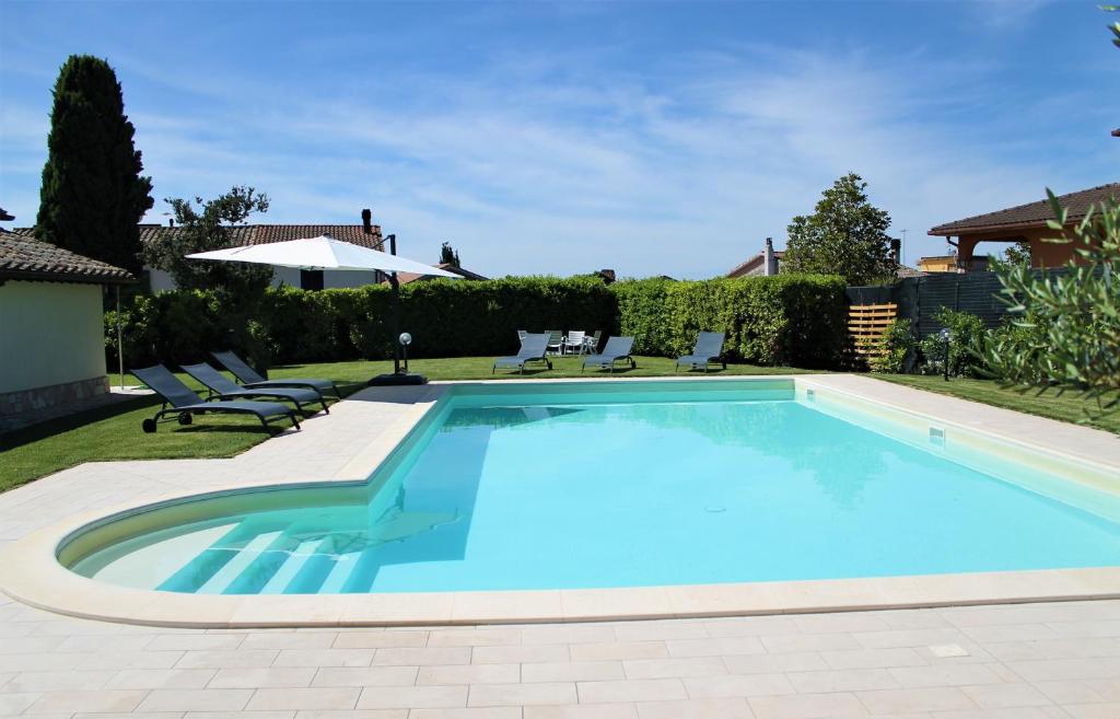 ColtodinoLO SCRIGNO COUNTRY HOUSE的庭院内的游泳池配有椅子和遮阳伞