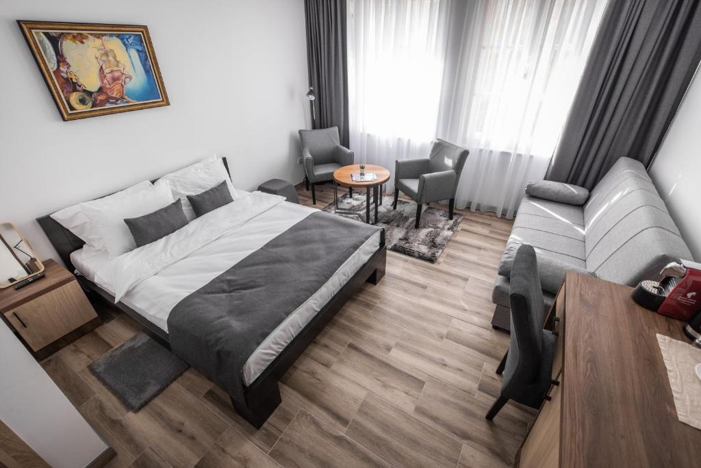 利塔尼Vila Greta by Hotel Ramonda的一间卧室配有一张床、一张沙发和一张桌子