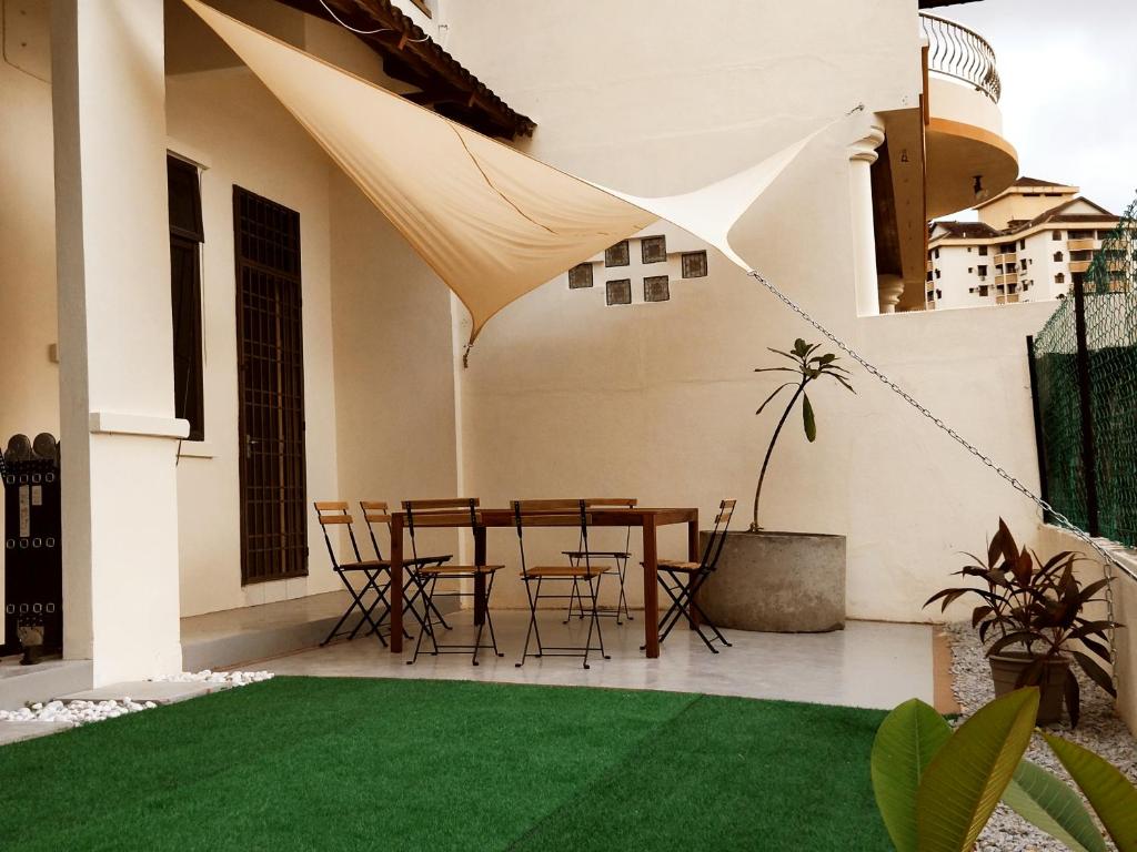 峇都丁宜Pinang Beach Cottage @ Ferringhi的天井配有桌椅和绿草