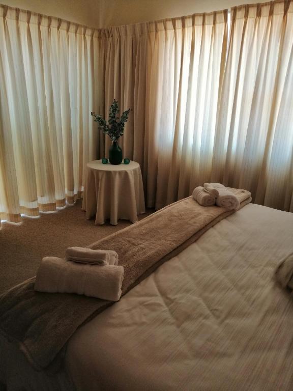 塞吉菲尔德Villa Monique Self Catering Apartment的一间卧室配有一张大床和毛巾