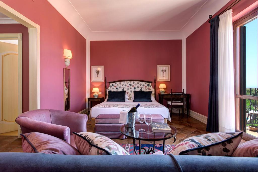 马尔萨拉Hotel Baglio Oneto dei Principi di San Lorenzo - Luxury Wine Resort的带床和沙发的客厅