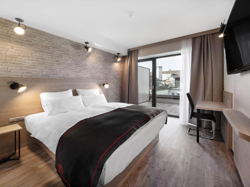 布达佩斯DORMERO Hotel Budapest的酒店客房设有一张大床和一张书桌。