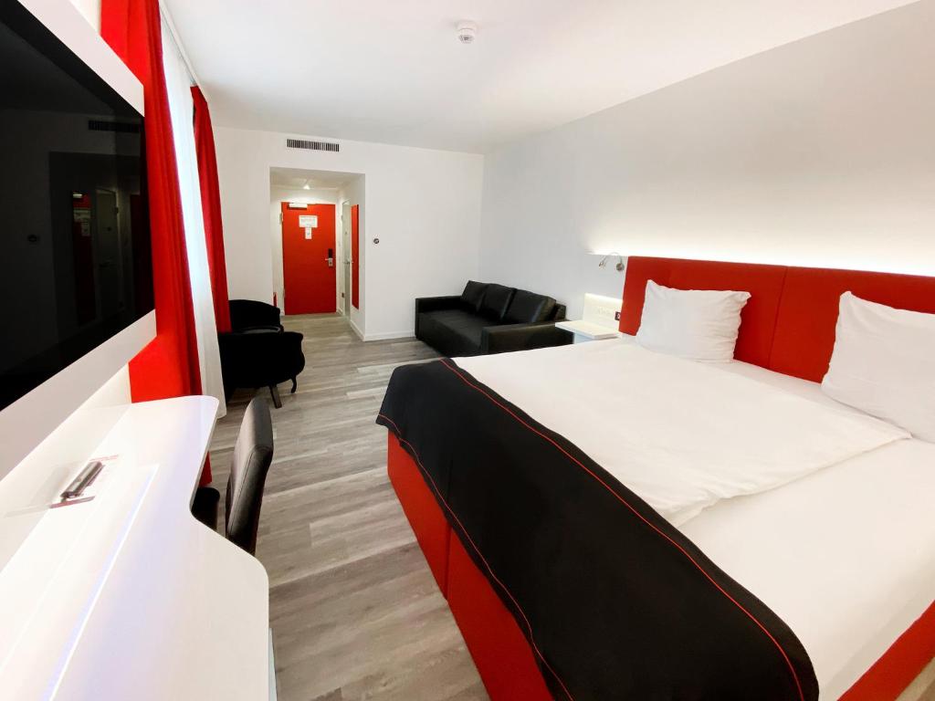 达姆施塔特DORMERO Hotel Darmstadt的酒店客房设有床和客厅。