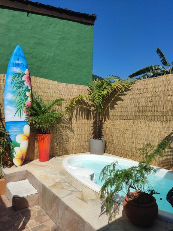 伊利亚贝拉Recanto Toca das Plantas de Ilhabela I的浴缸位于墙上,配有冲浪板