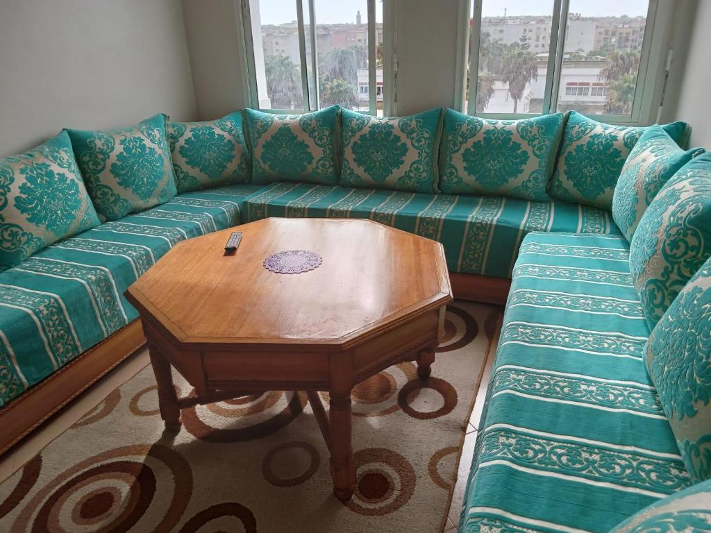 卡萨布兰卡Appartement près de casanearshore et l'OFPPT的客厅配有带木桌的绿色沙发