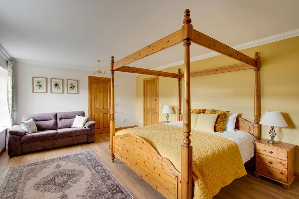 弗福尔Home Farm B&B - Sunflower Room的一间卧室配有天蓬床和沙发