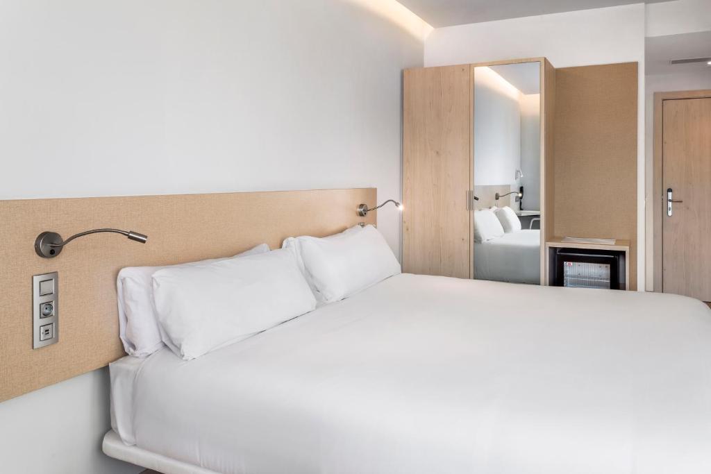 马拉加B&B HOTEL Málaga Centro的卧室配有白色的床和镜子